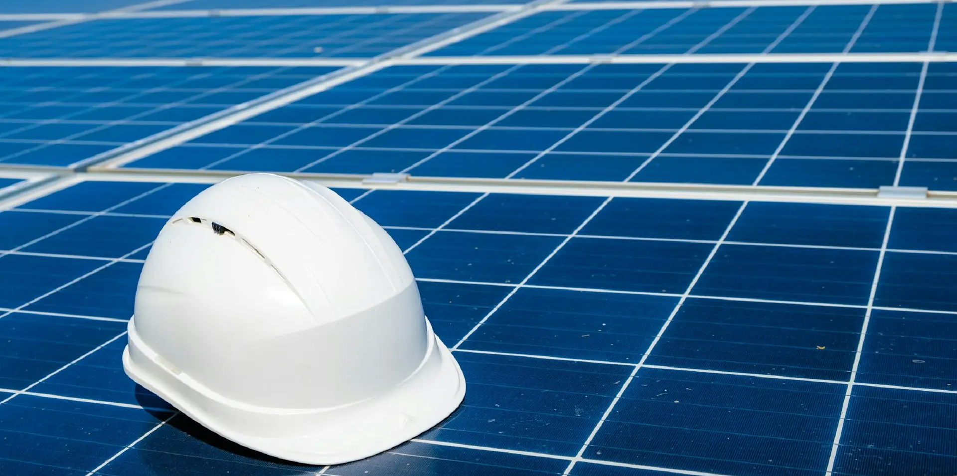 a white hard hat sitting on top of a solar panel